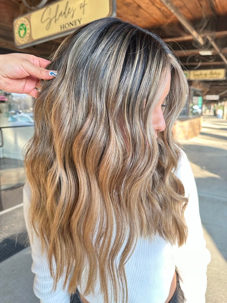 A woman is getting her hair done in front of a sign.