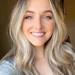 A woman with long blonde hair is smiling for the camera.