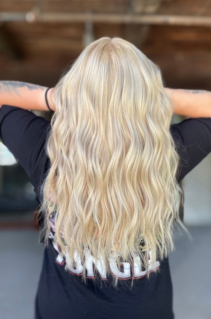 A woman with blonde hair is wearing a black shirt with the word jungle on the back.