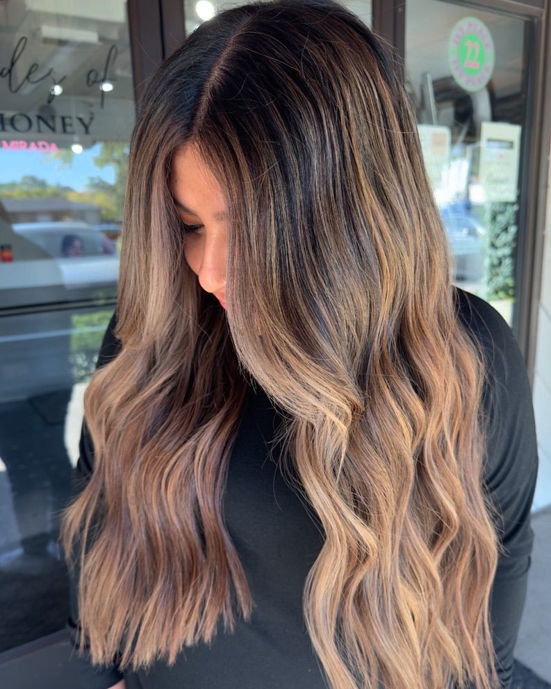 A woman with long brown hair is wearing a black shirt.