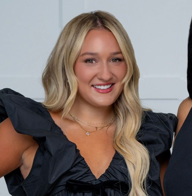 A woman is taking a selfie in front of a mirror.