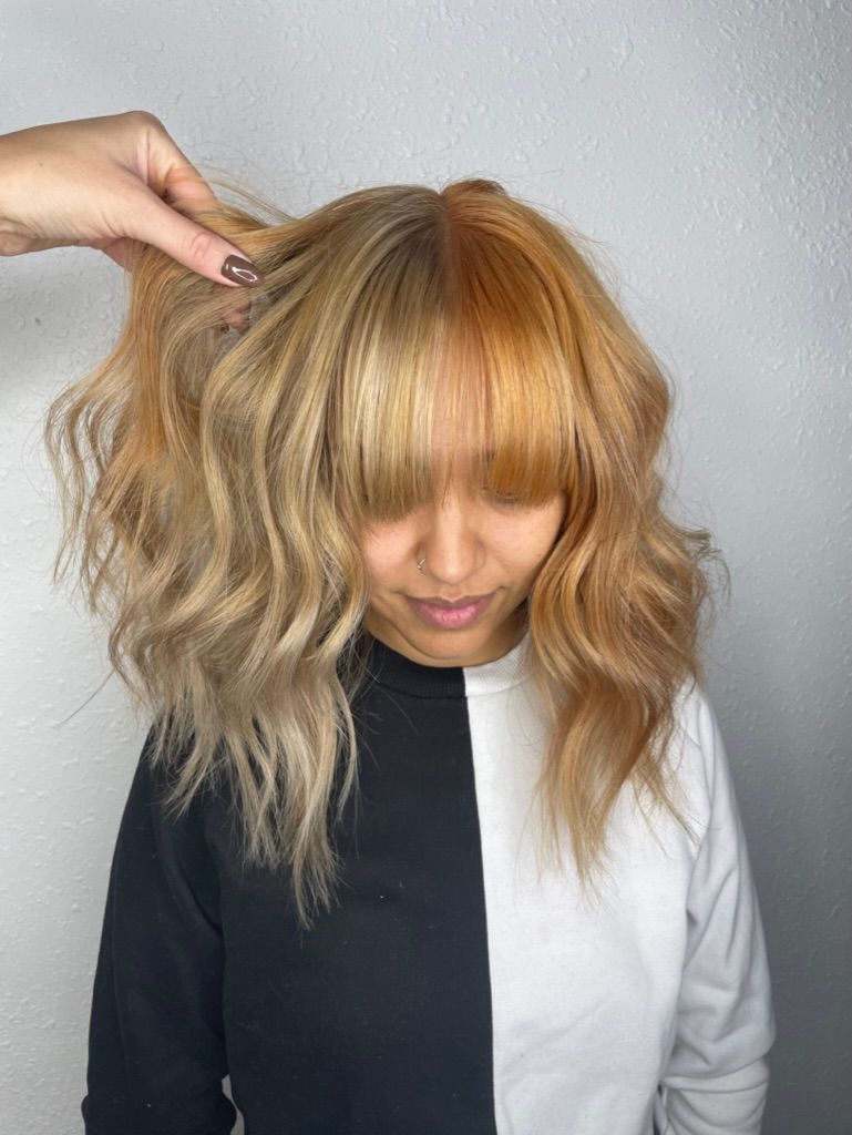 A woman with red hair is wearing a purple sweater.