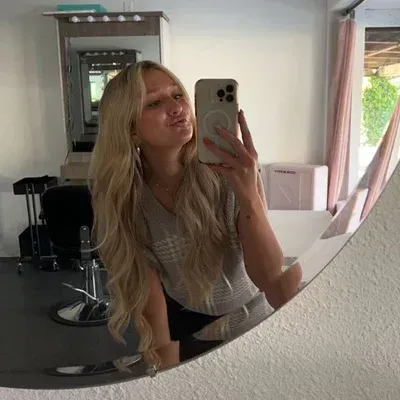 A woman is taking a selfie in front of a mirror.