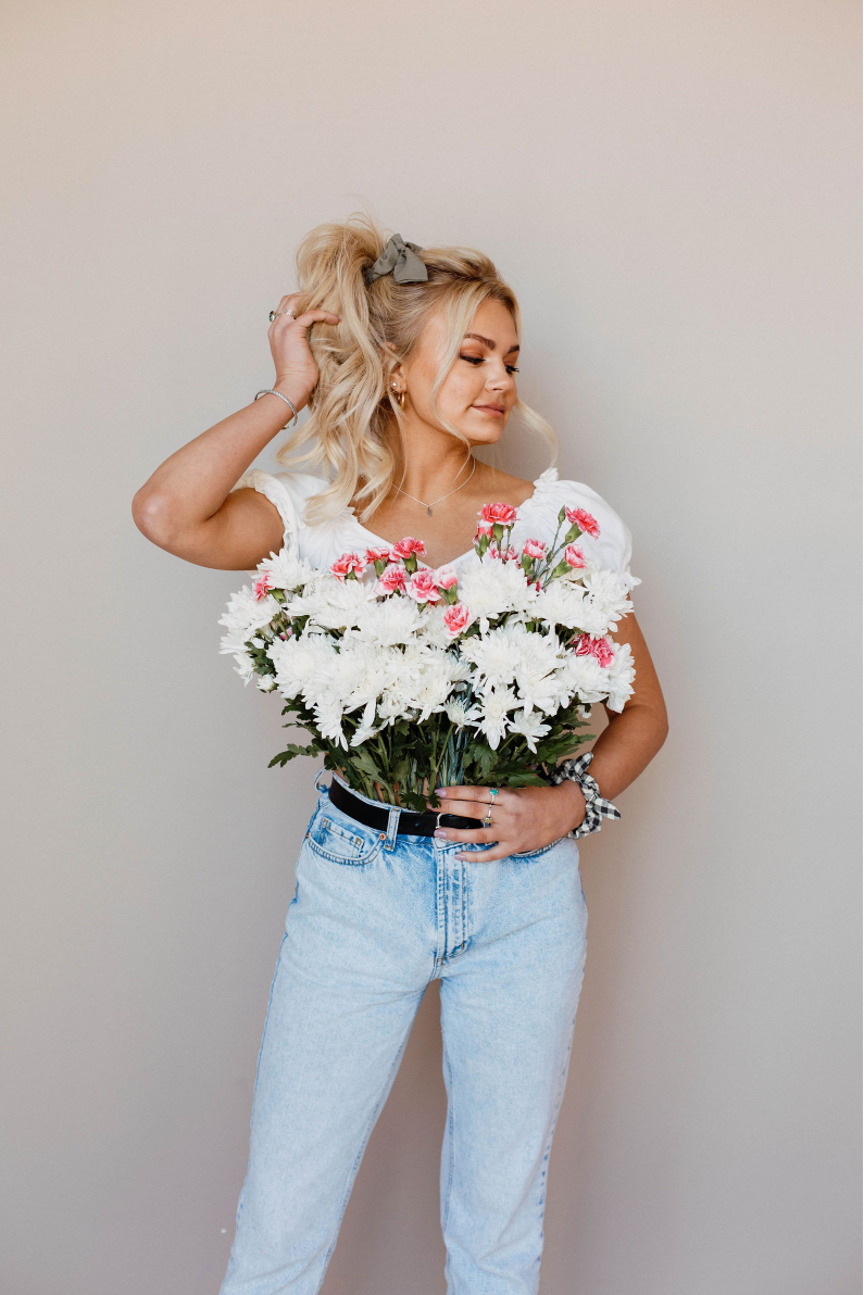 A woman is holding a bouquet of white flowers.