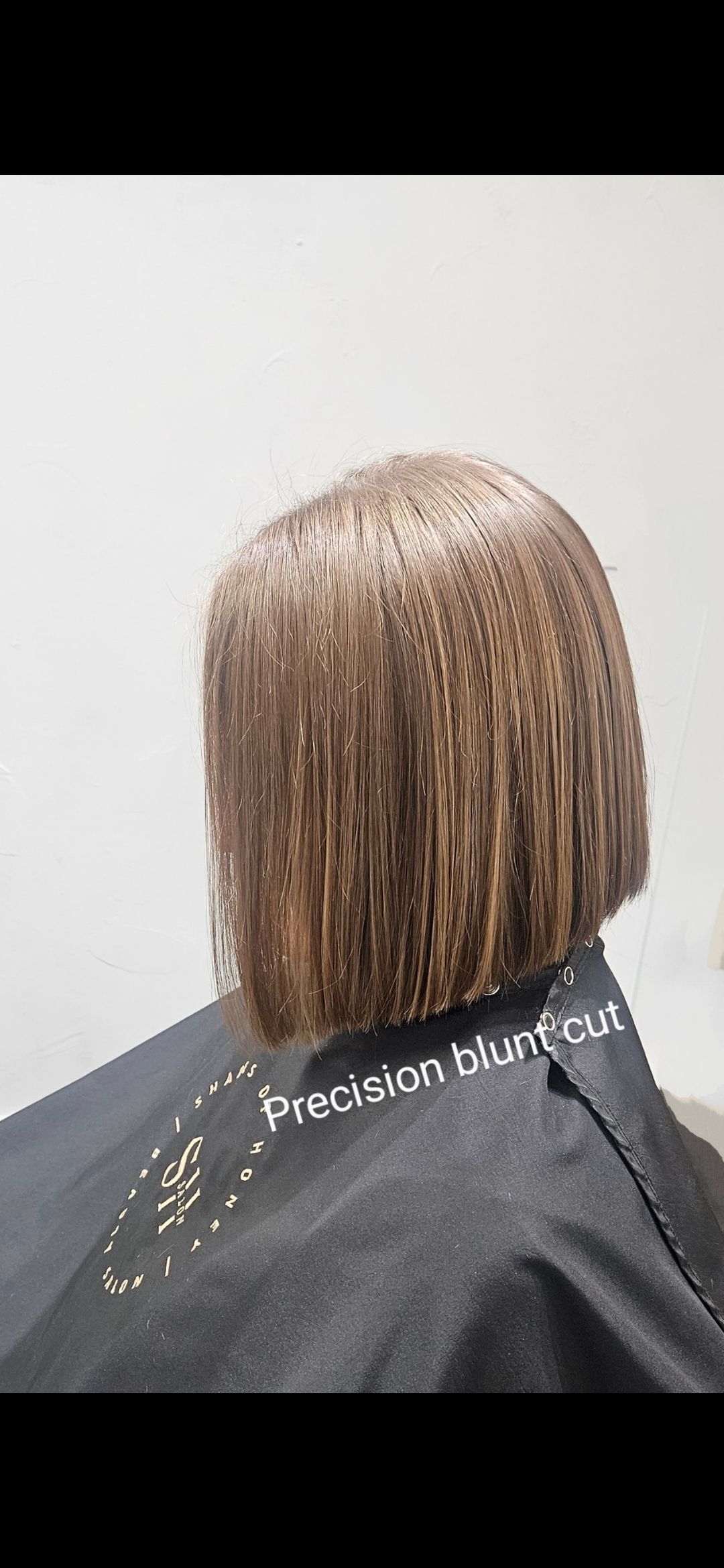 A woman is getting her hair cut in a salon.
