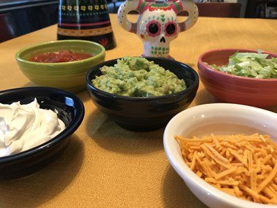 table with taco toppings in bowls