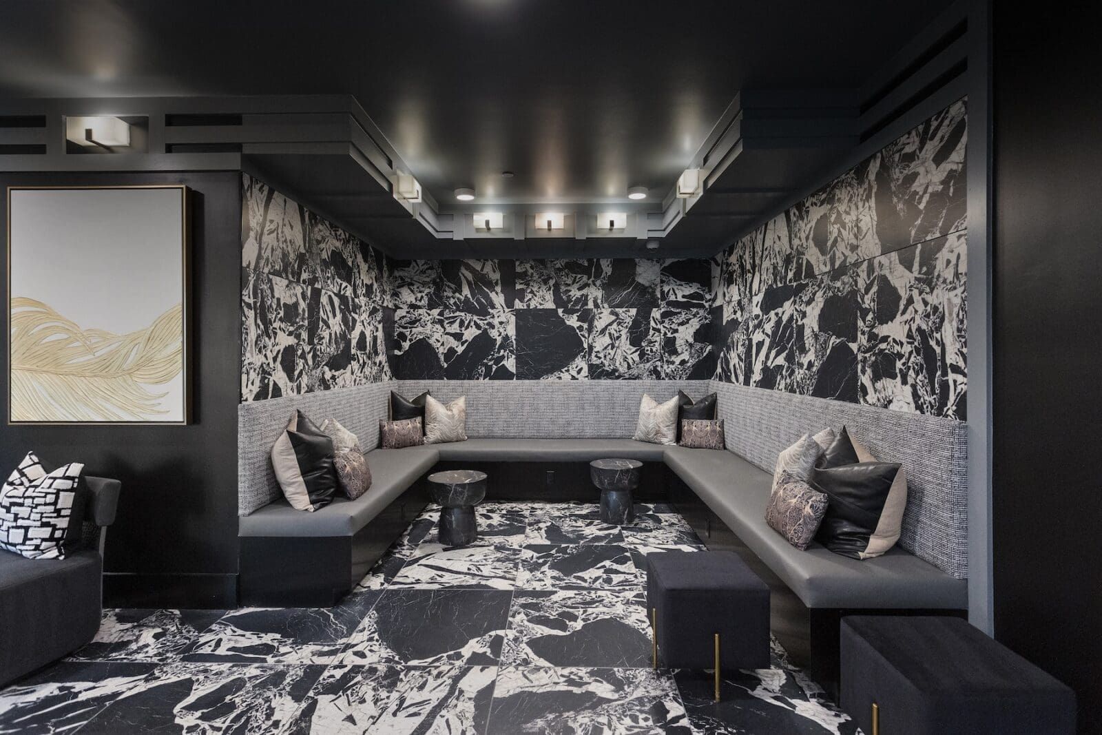 Cozy lounge with black and white patterned walls, gray seating, and art at Echo Biltmore in Phoenix, AZ..
