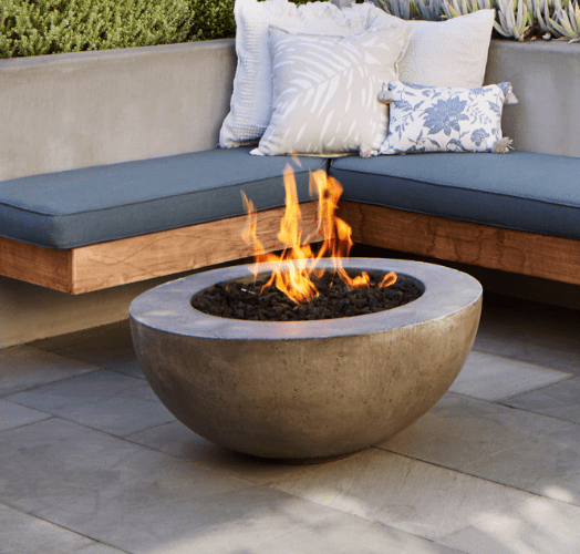 A lit fire pit on a patio with seating at Echo Biltmore in Phoenix, AZ..