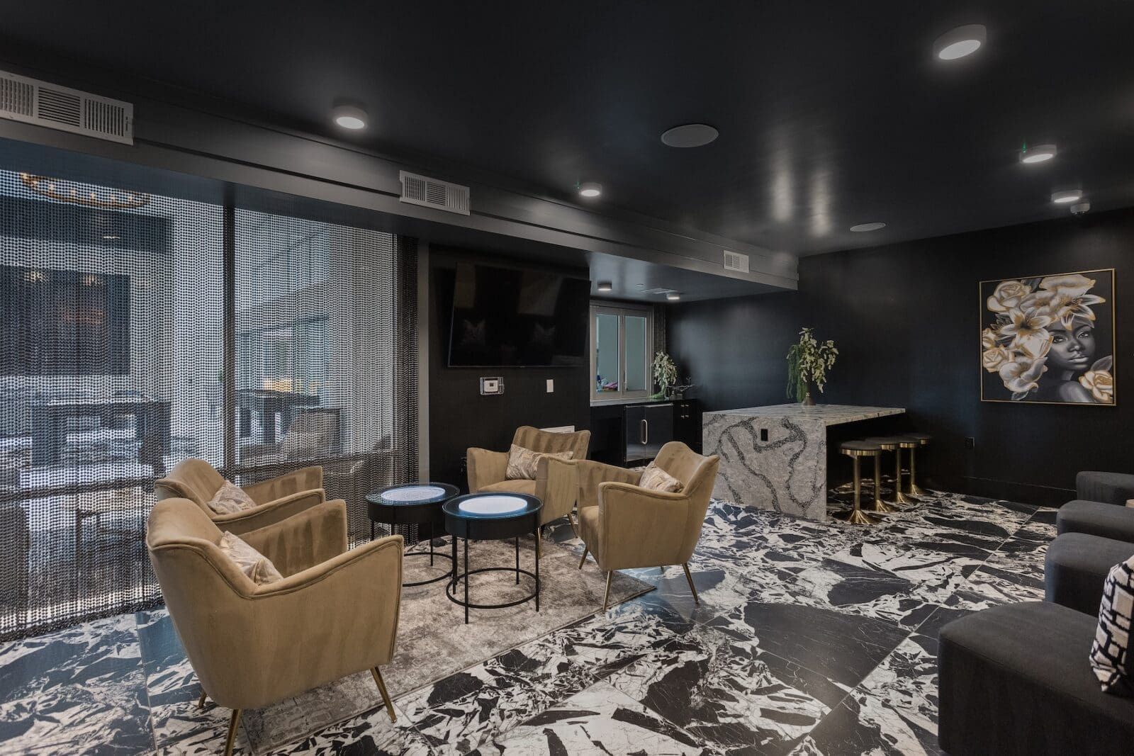 A lounge area with gold chairs, a marble bar, and abstract patterned flooring at Echo Biltmore in Phoenix, AZ..