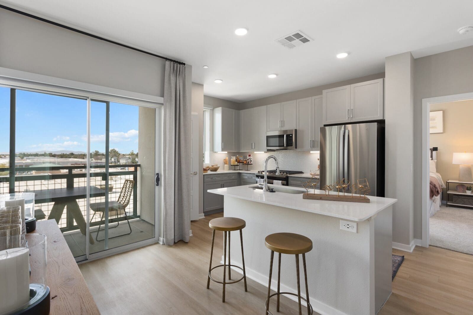 Modern kitchen with island, balcony overlooking water, and light gray cabinets at Echo Biltmore in Phoenix, AZ..
