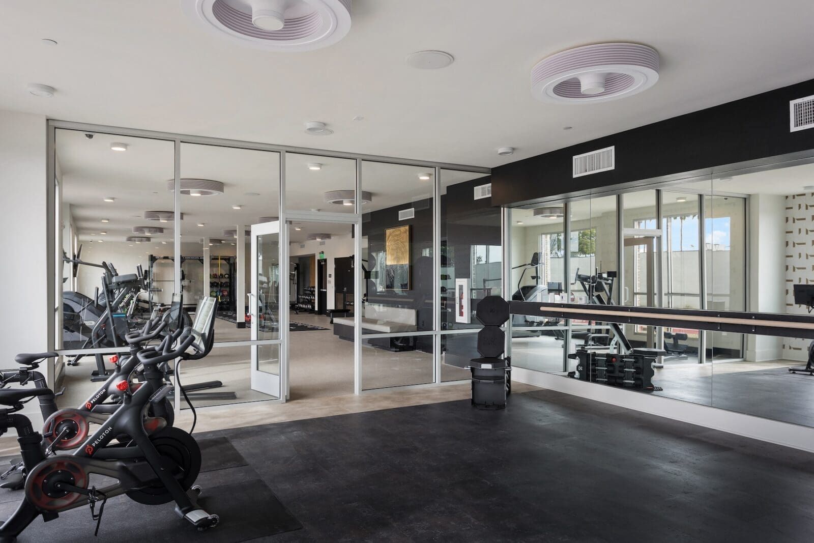 Gym interior with workout equipment, mirrors, and black rubber flooring at Echo Biltmore in Phoenix, AZ..