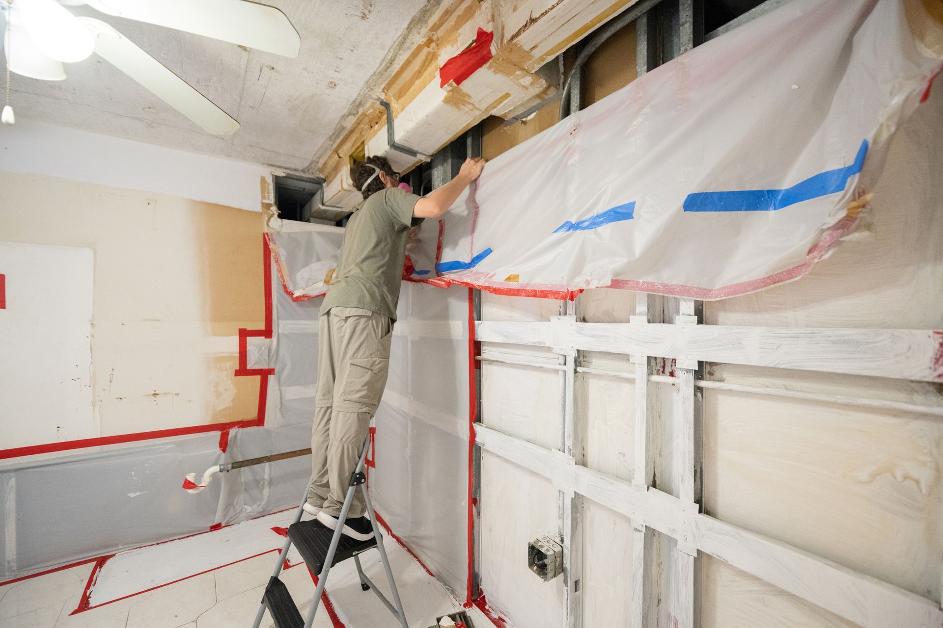 Technician inspects the walls after mold remediation services in an apartment kitchen.