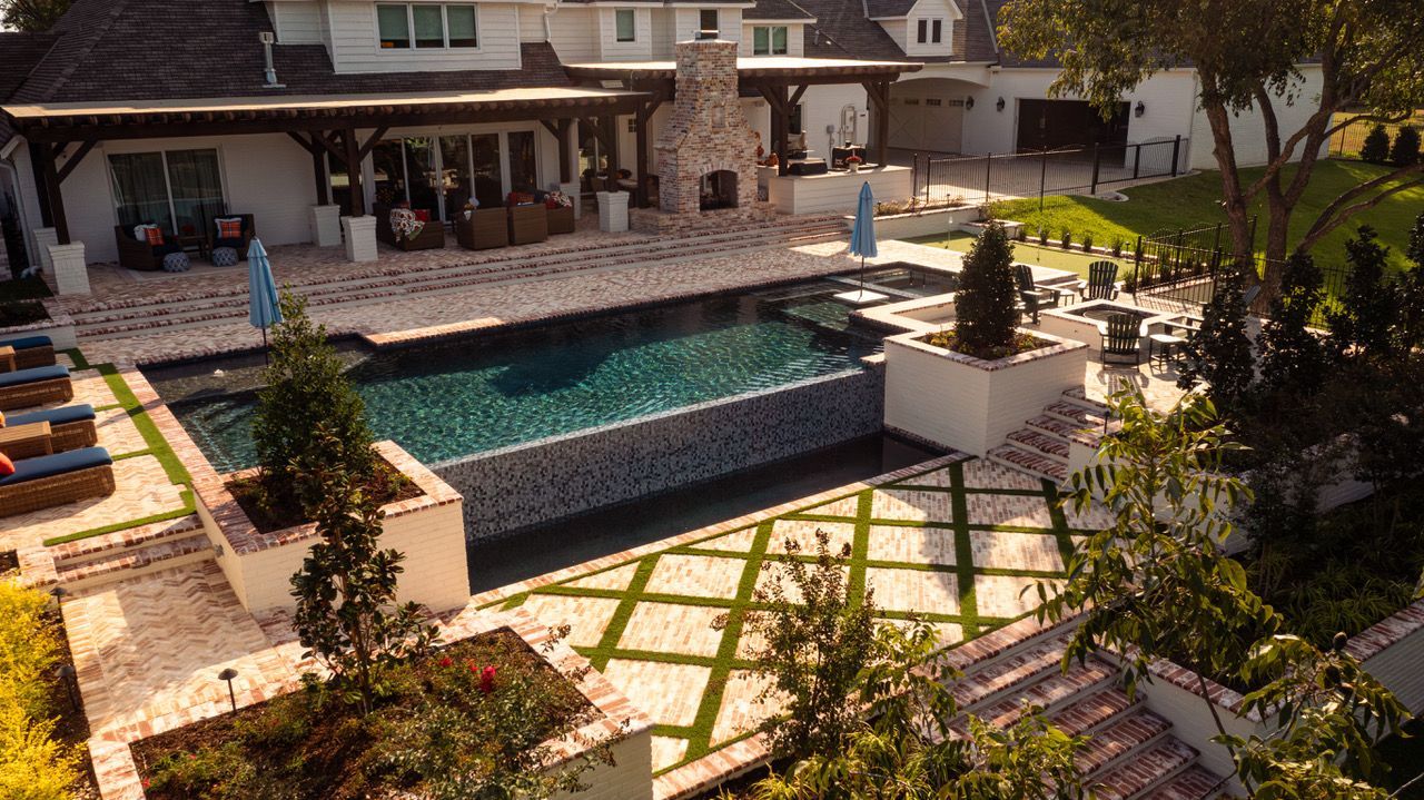 Luxurious backyard with pool, patio, and outdoor fireplace. 