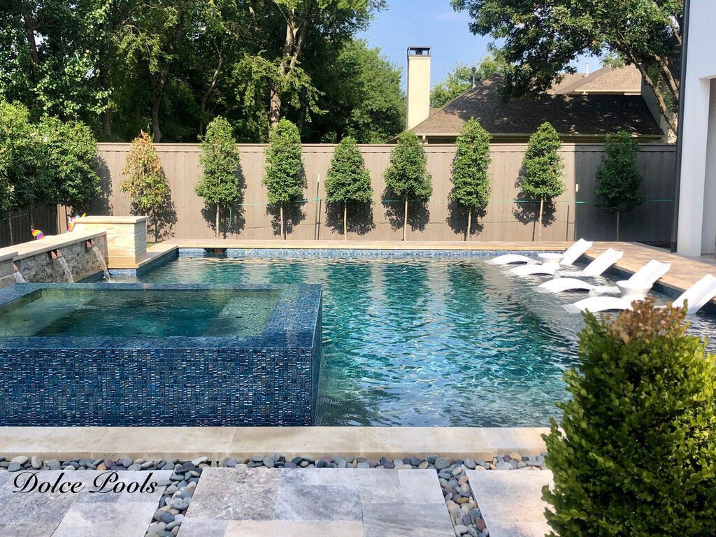 backyard pool with trees and lounge chairs