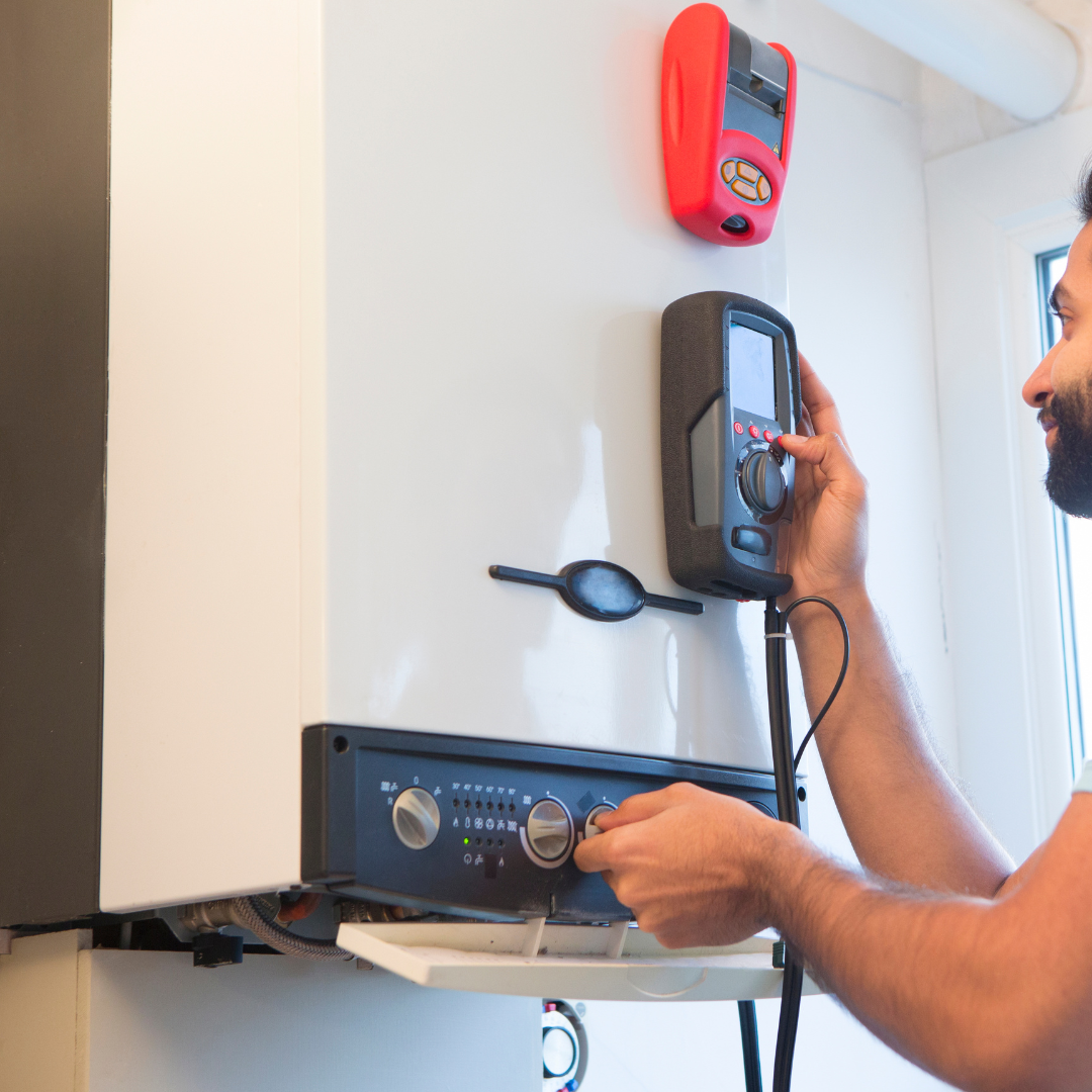 A man with a beard is working on a boiler