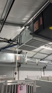 A room with a lot of pipes hanging from the ceiling.