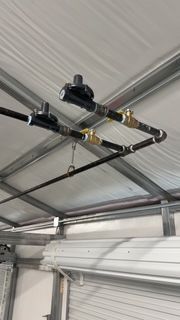 A bunch of pipes are hanging from the ceiling of a building.