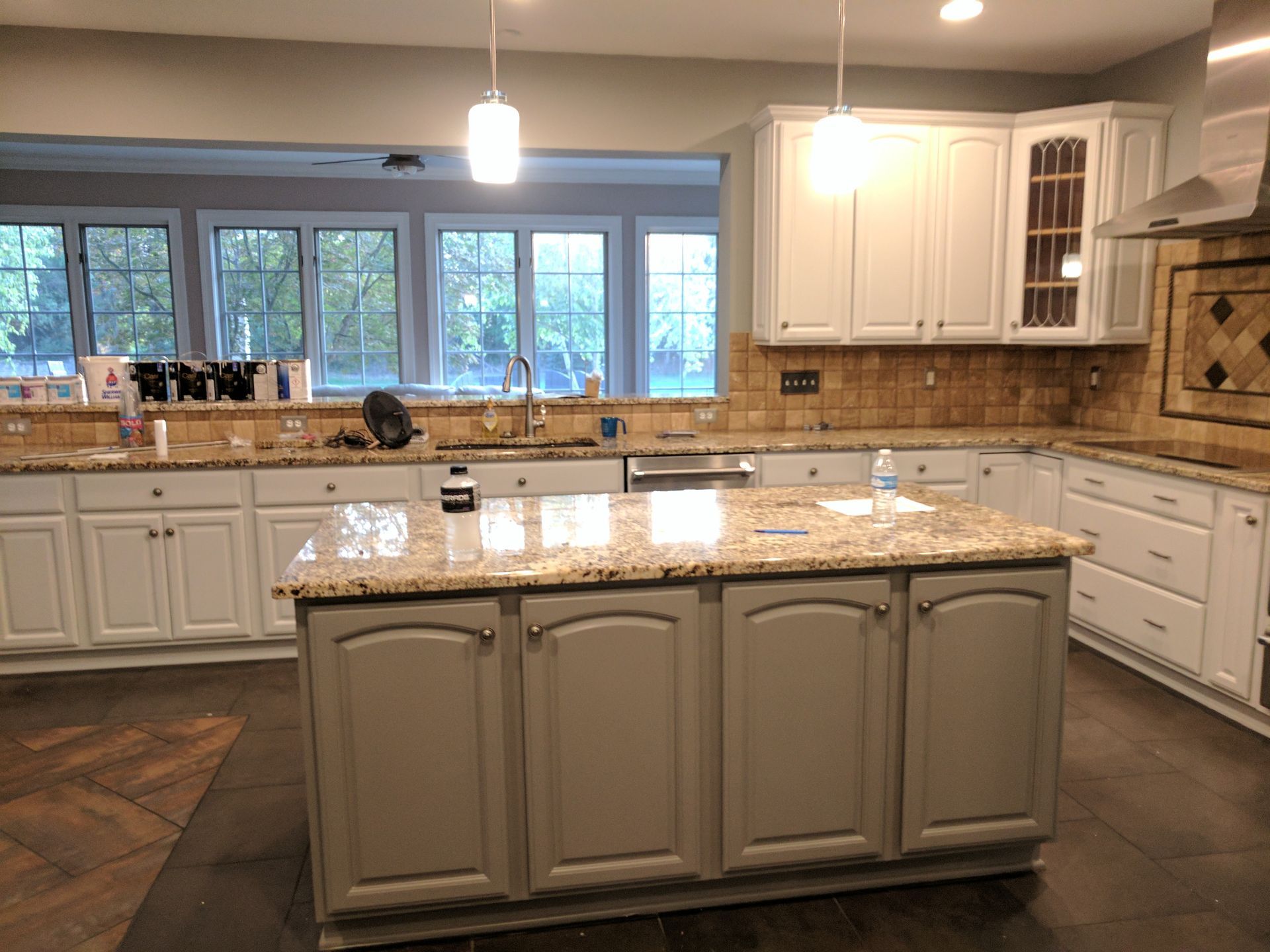 Kitchen with white and gray cabinets, granite countertops, and an island.