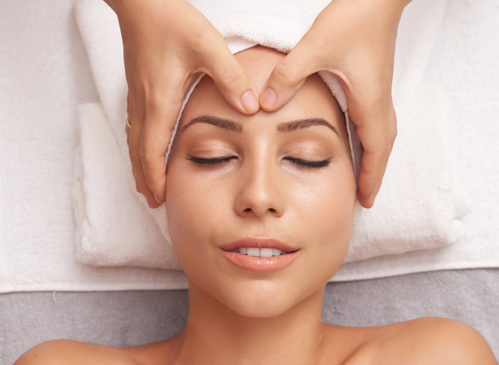 A woman is getting a head massage at a spa.