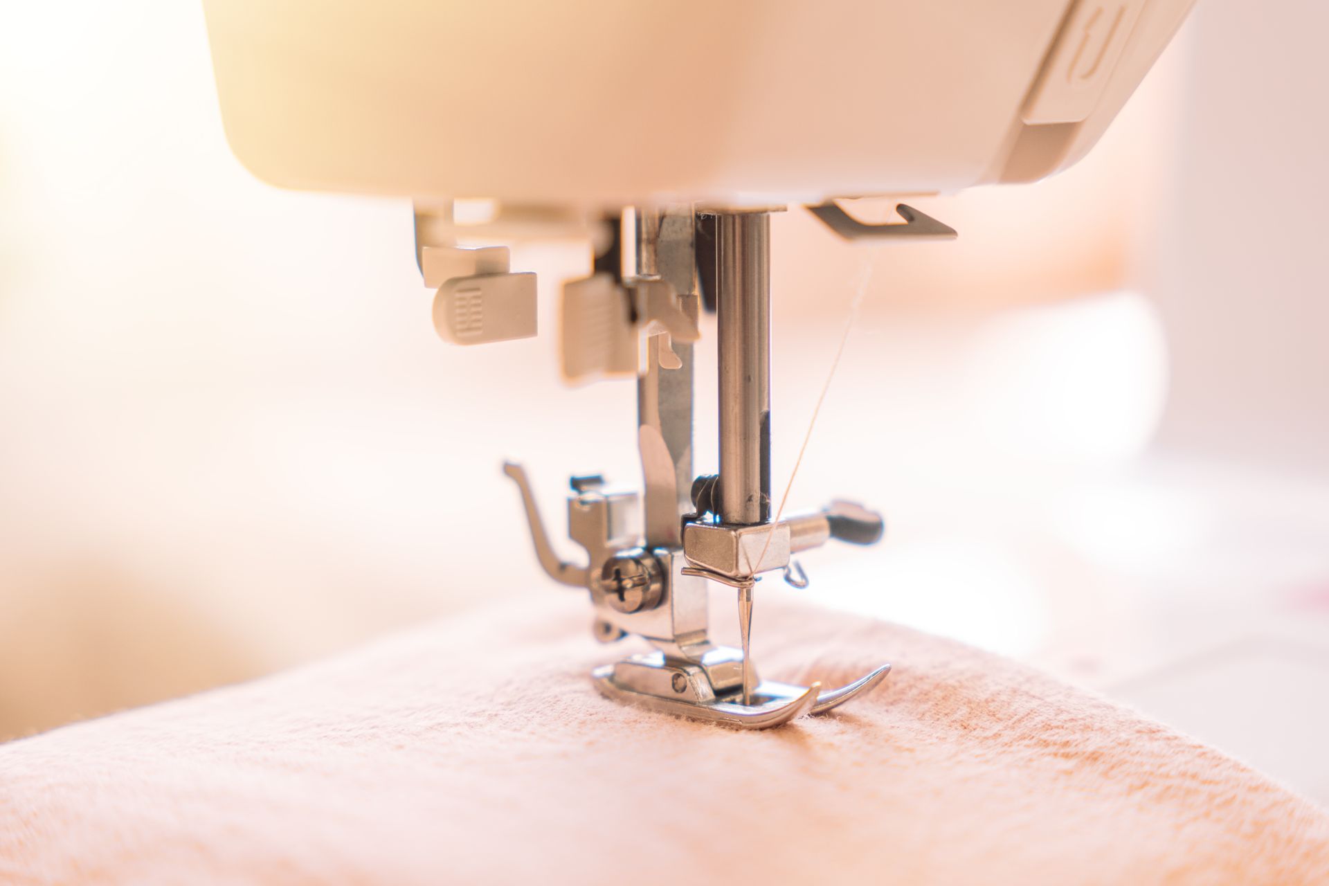 Close-up of a presser foot on a white sewing machine — precision craftsmanship