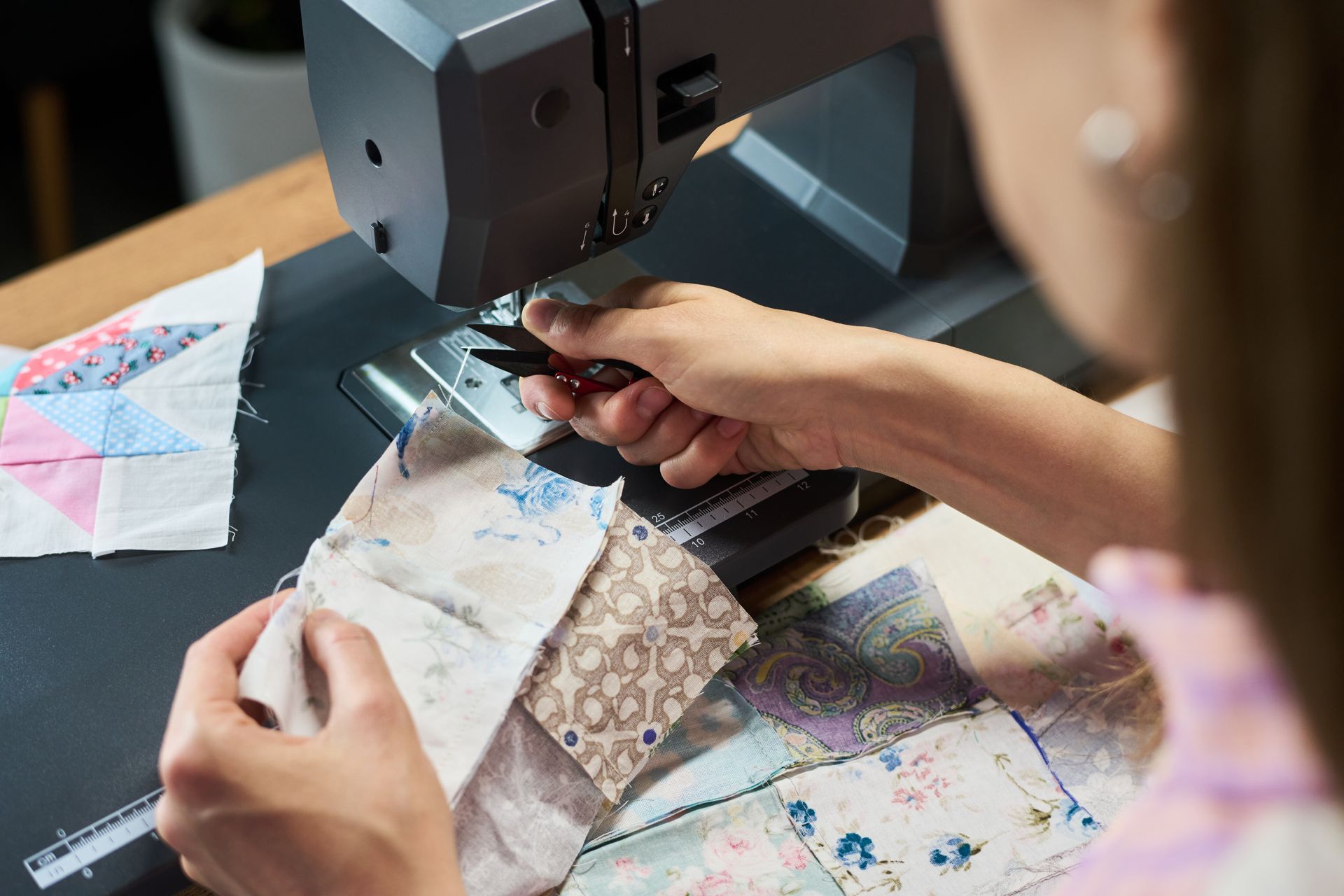 Woman assembling a patchwork quilt with colorful fabric squares