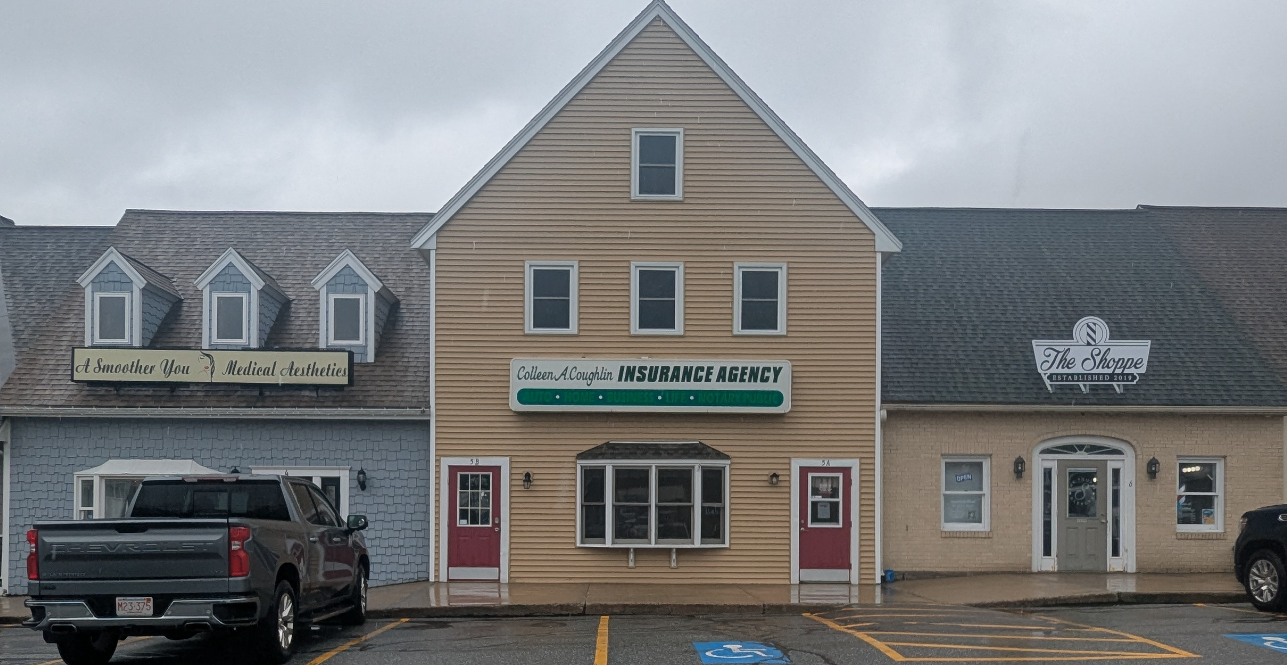 A man in a suit holds a piece of paper in front of a building