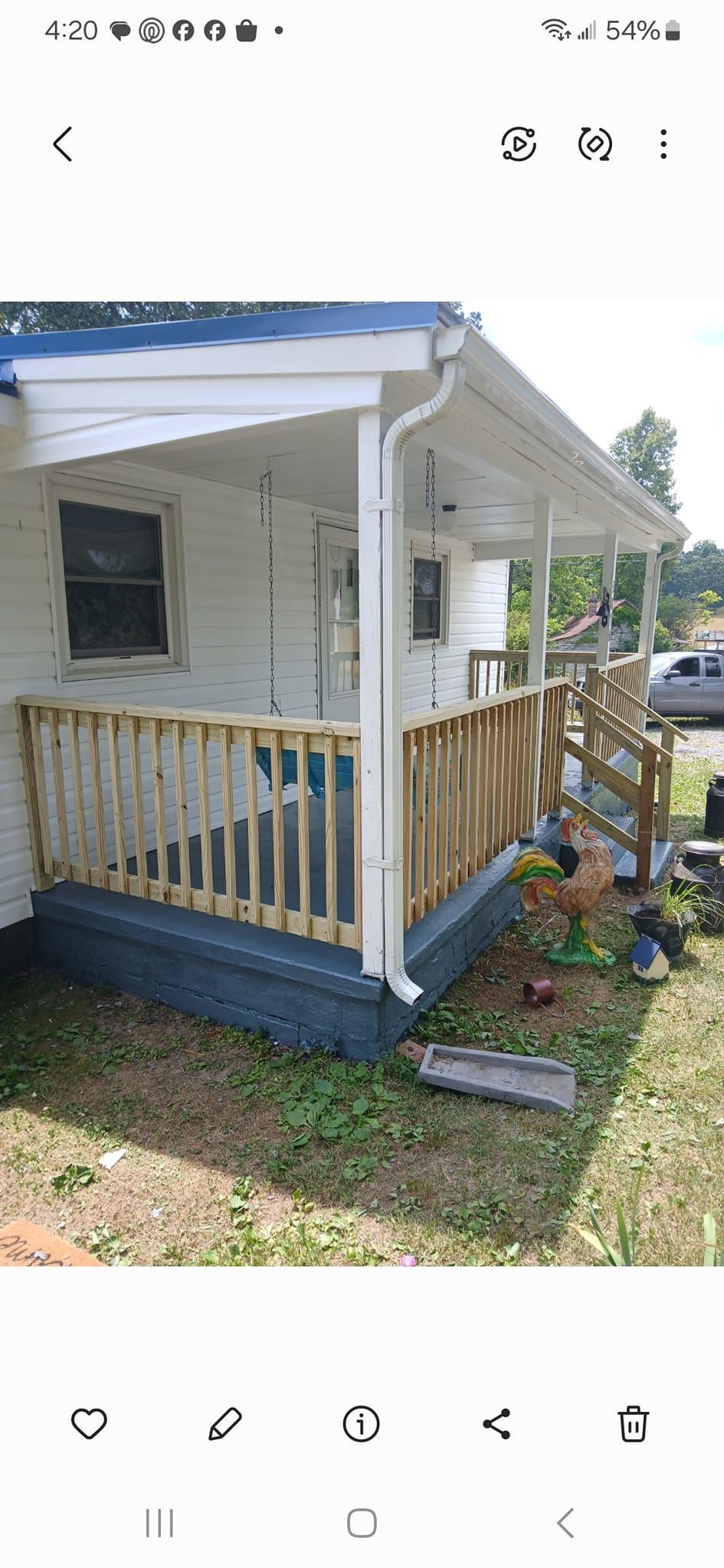 A patio area with a white double door and a detached white gutter hanging diagonally from the porch ceiling to the floor.