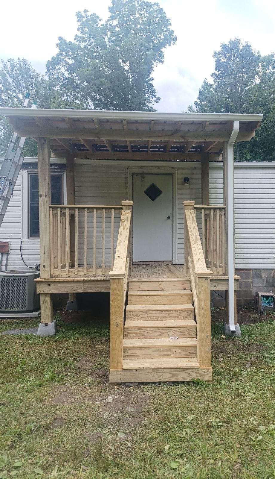 A person wearing orange and black safety gloves uses a screwdriver to wire a light switch on a white wall.