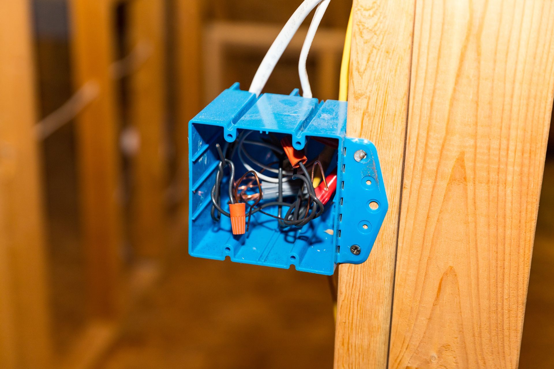 Hands adjust a glowing, geometric wire-frame pendant light hanging from a ceiling.