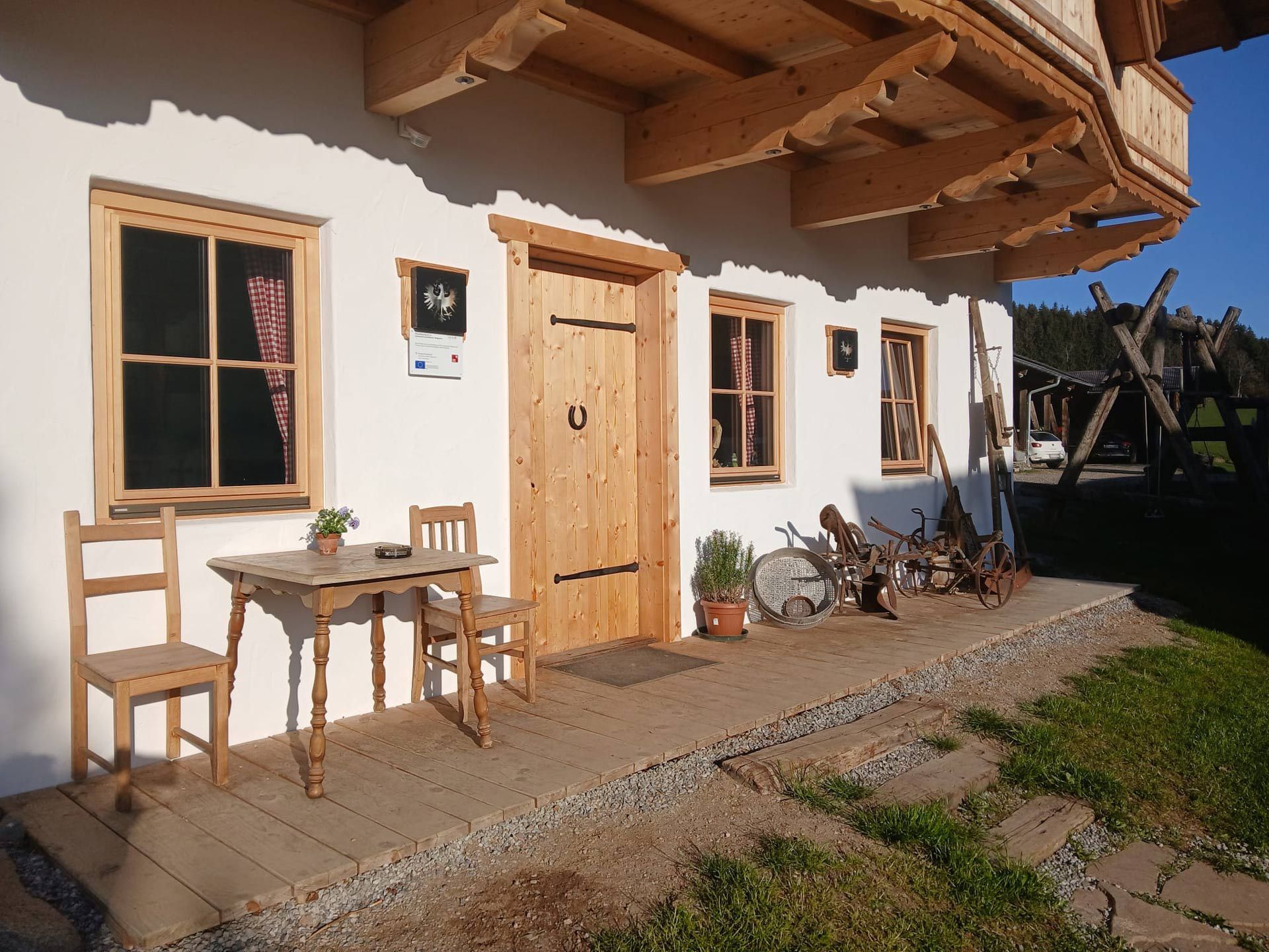 A white house with a wooden table and chairs in front of it