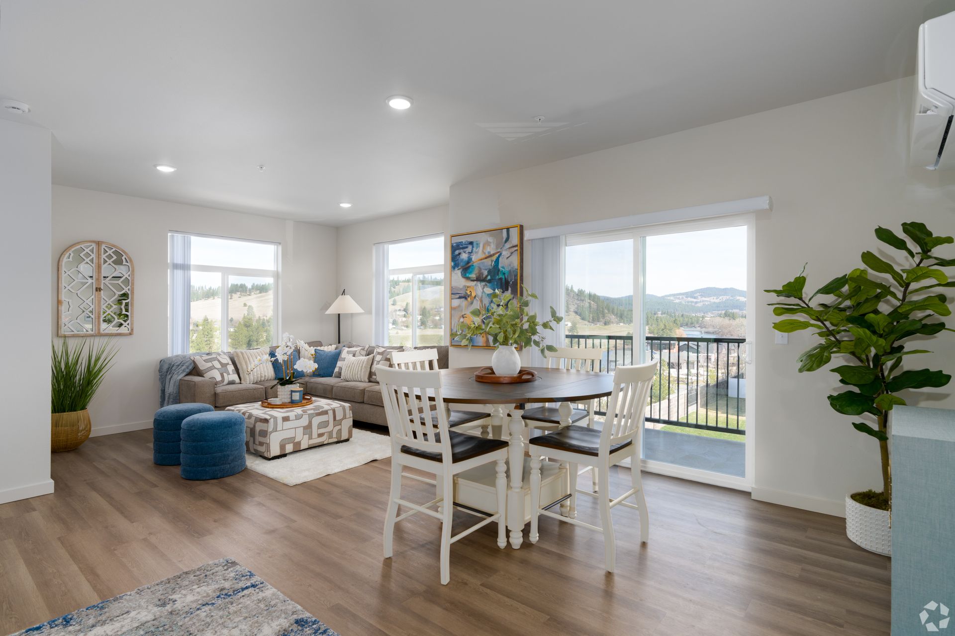 A living room with a dining table and chairs and a balcony.