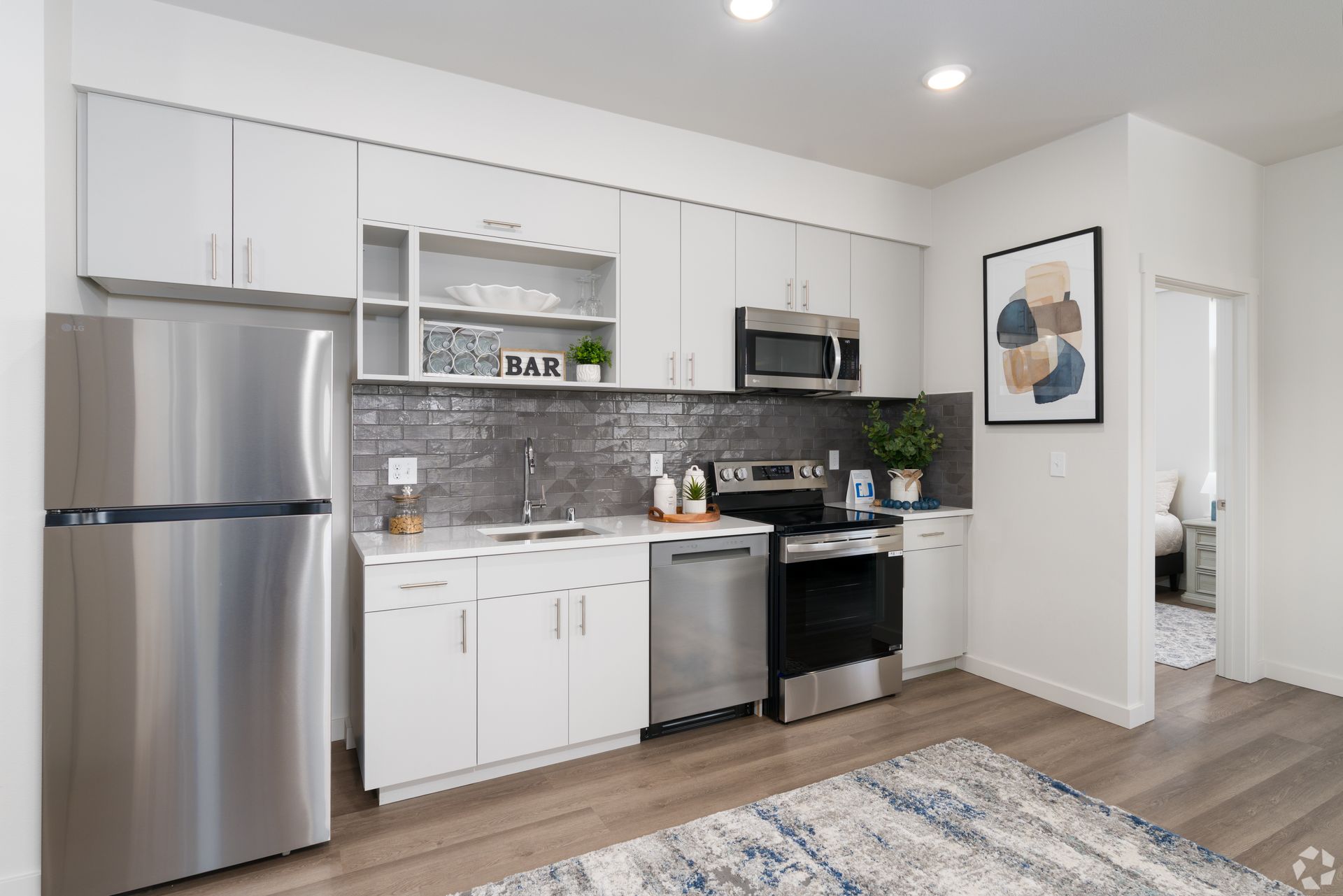 A kitchen with stainless steel appliances and white cabinets.
