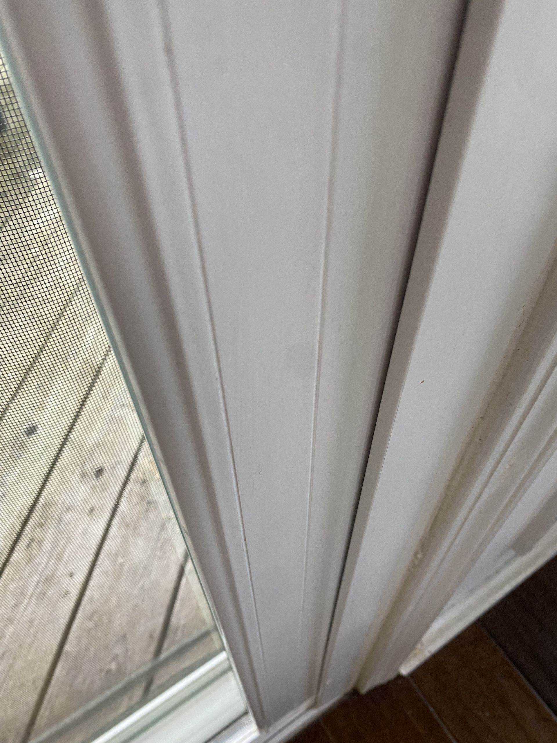 a close up of a sliding glass door with a white trim .
