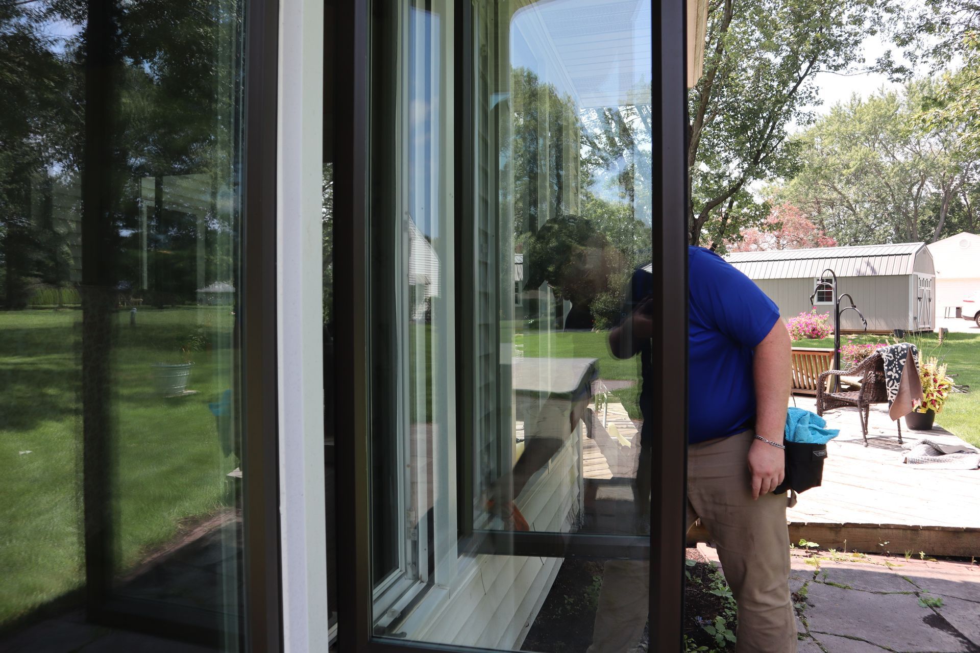 a man is standing in front of a sliding glass door .