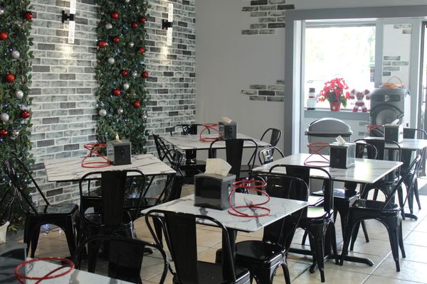 A restaurant with tables and chairs and a sign on the wall.