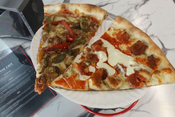 A pizza with a lot of toppings on it is on a plate.