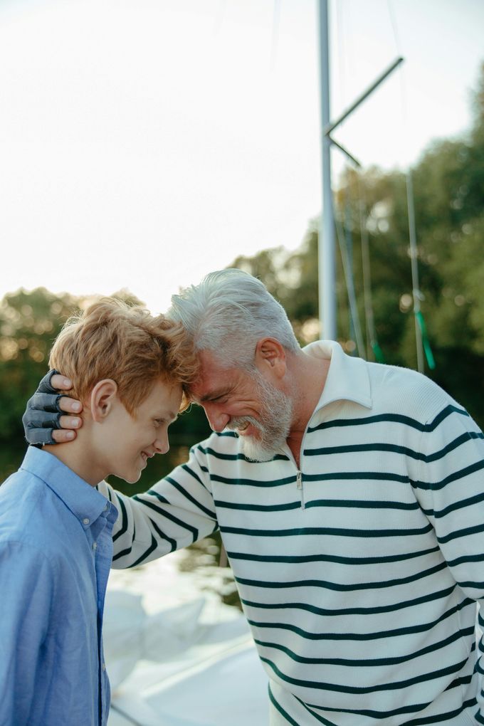 A man and a boy are standing next to each other on a boat.