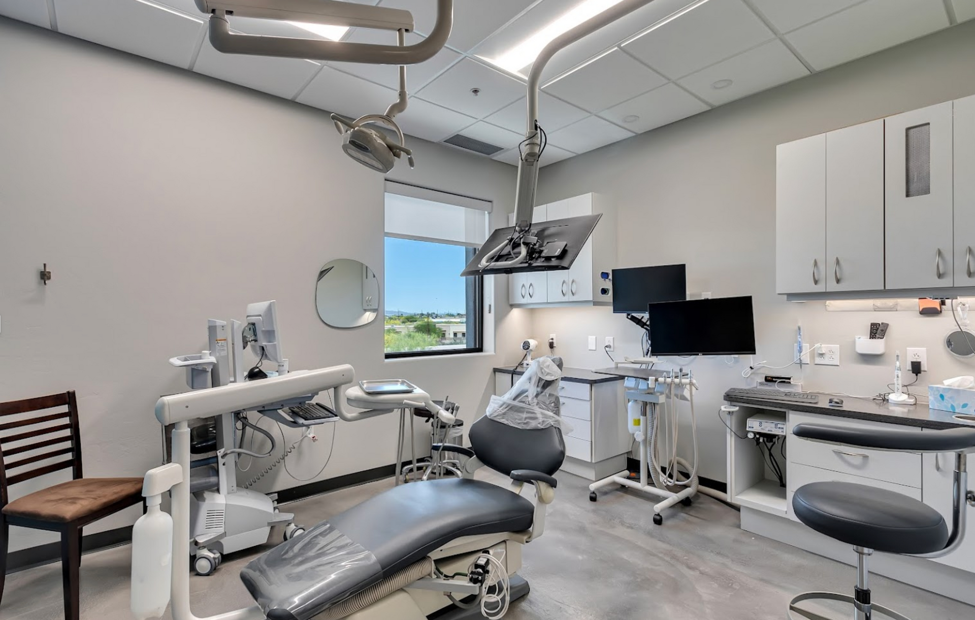 A dental office with a dental chair and a computer.