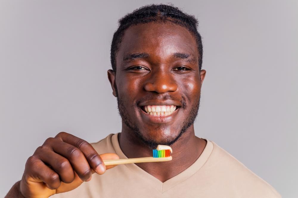 A man is brushing his teeth with a toothbrush.