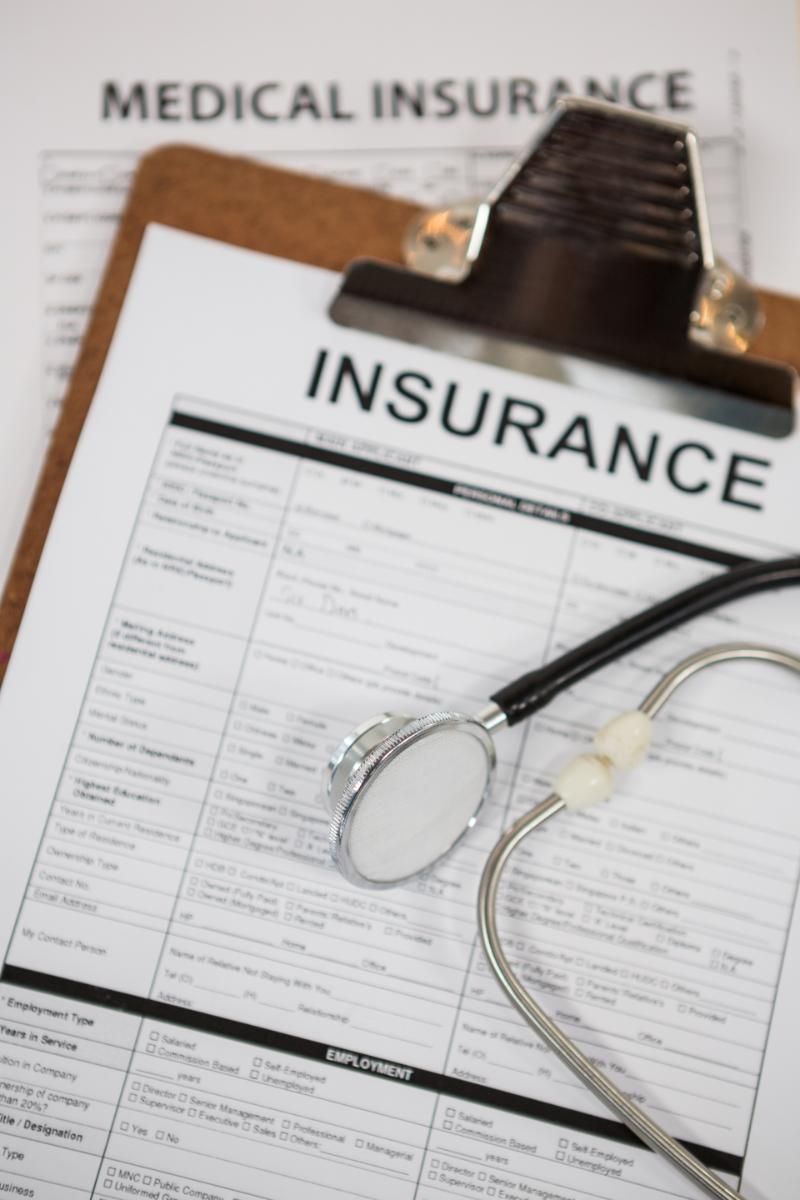 A clipboard with a medical insurance form and a stethoscope on it