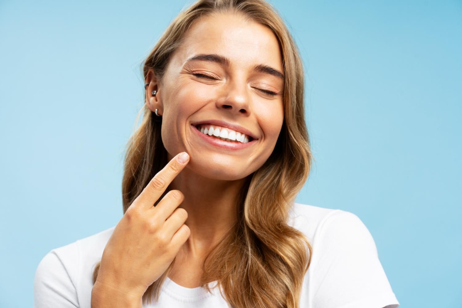 young person smiling confidently with dentures