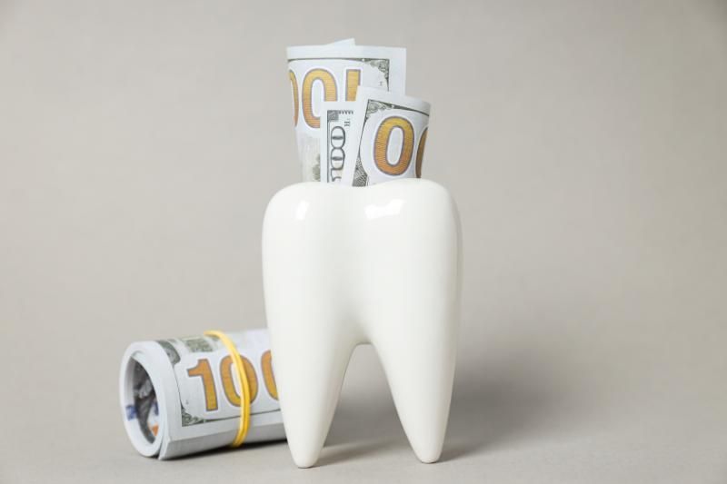 A tooth is sitting next to a roll of money.