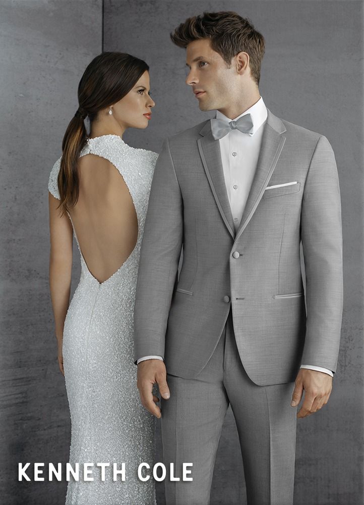 Man in patterned tuxedo with bow tie and woman in white lace dress.