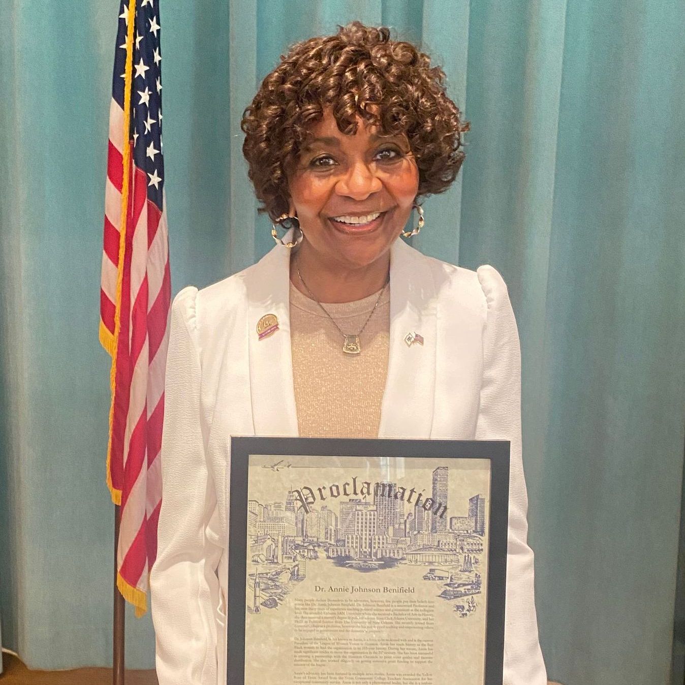 A woman is holding a proclamation in front of an american flag