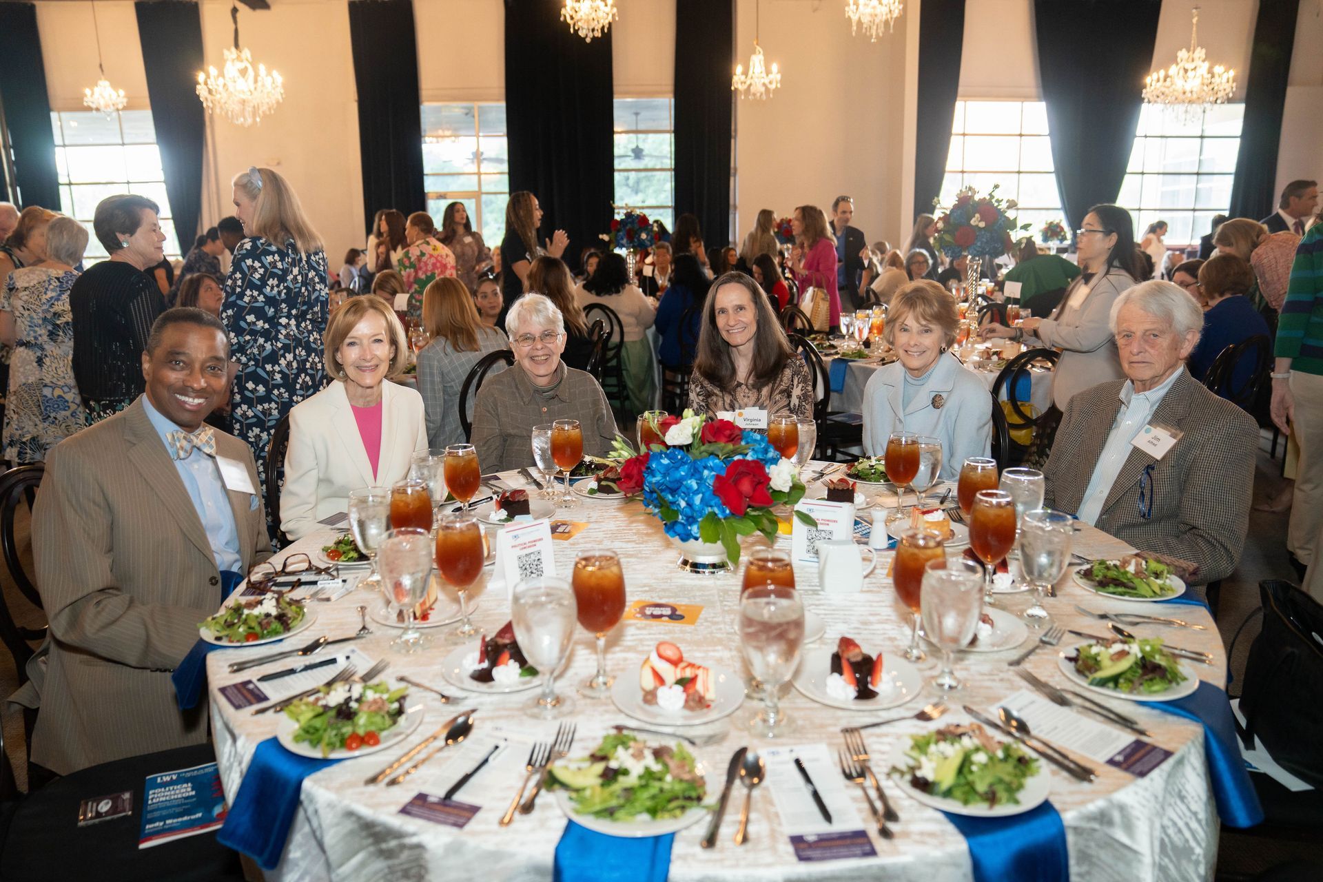 A group of people are sitting at a table with plates of food.