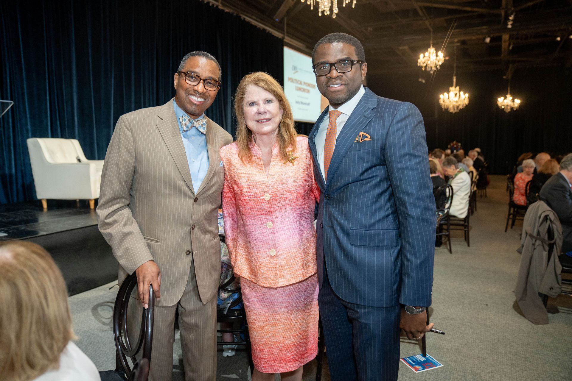 Two men and a woman are posing for a picture in a room.