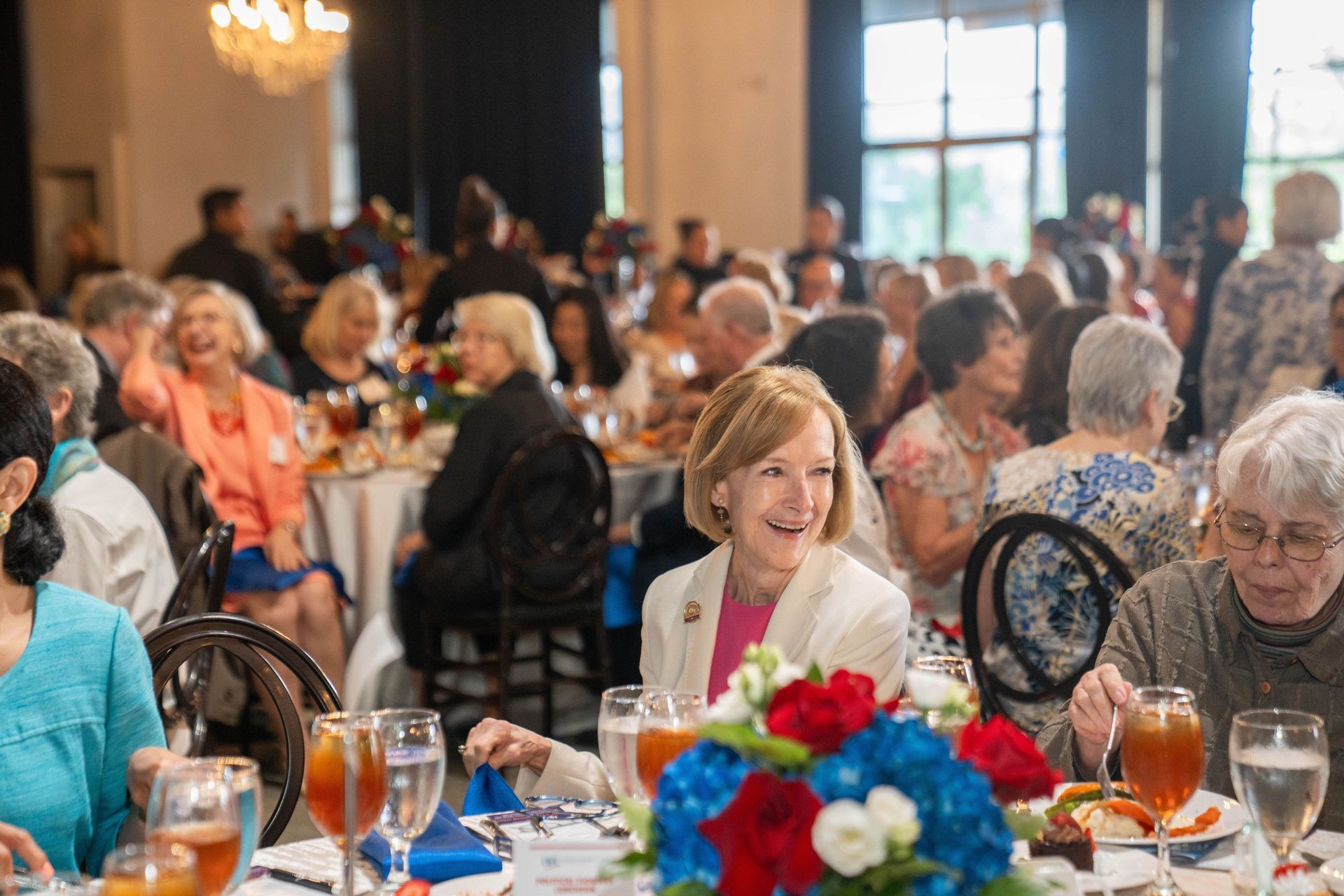 A large group of people are sitting at tables at a dinner party.