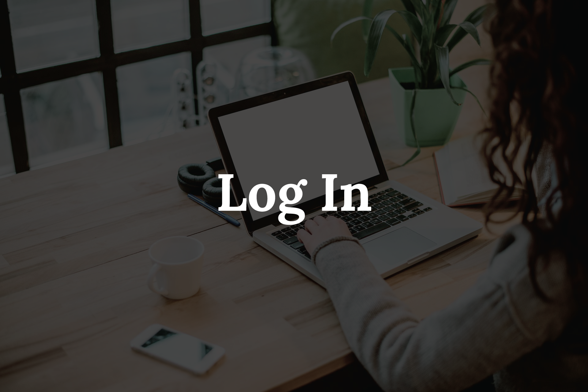 Person using laptop on wooden desk,