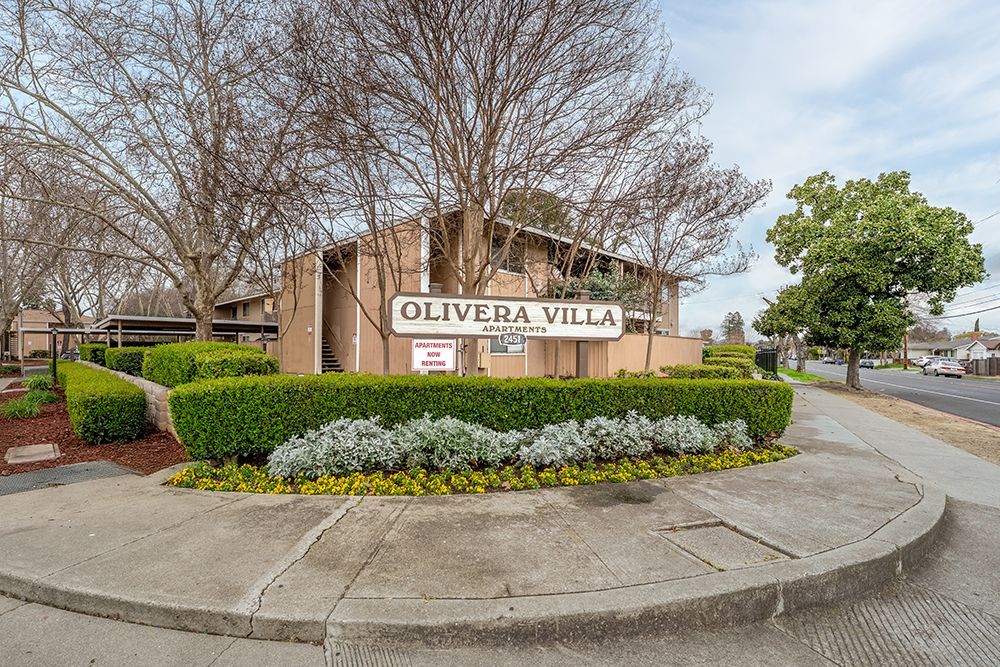 Entrance sign for Olivera Villa apartments with landscaping.