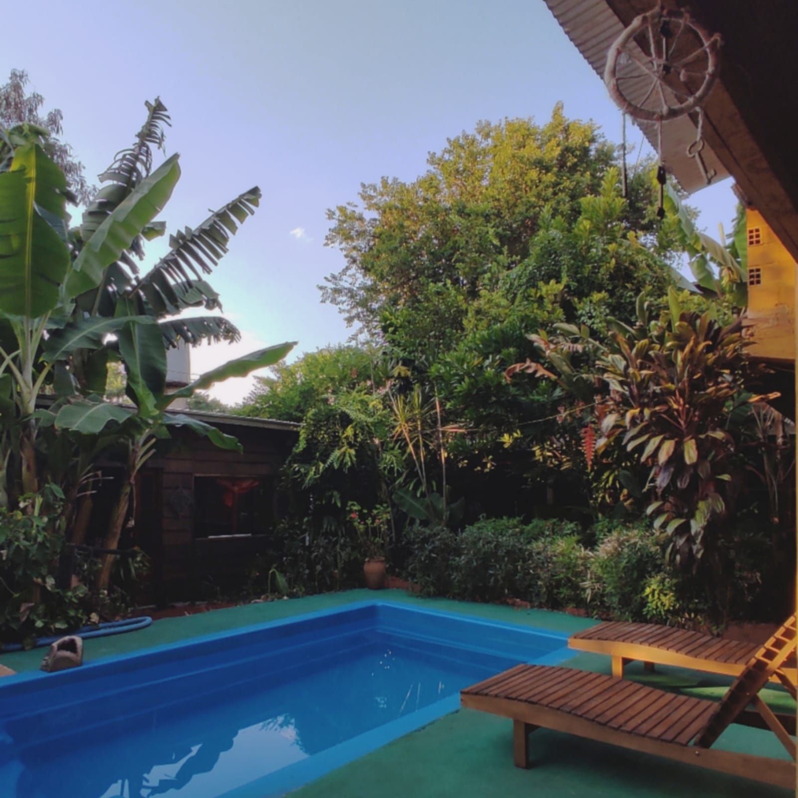 Una piscina con un atrapasueños colgando del techo.